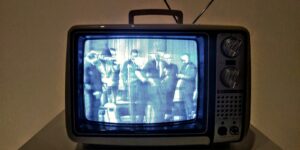 black crt tv turned on on white table