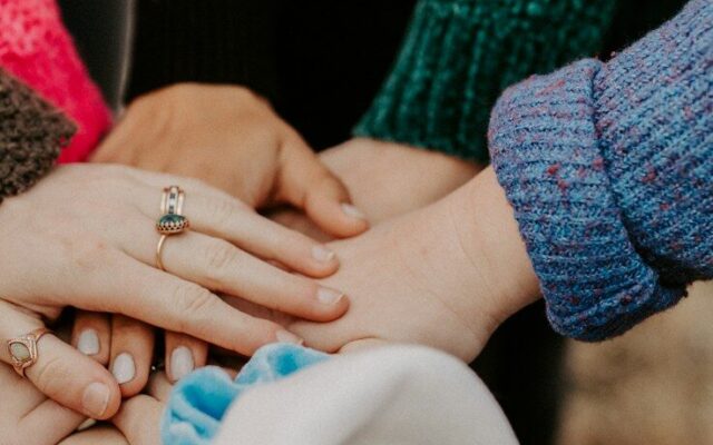 자발적 참여를 이끄는 커뮤니티, 그룹 기능 group stacking hands in colorful sweaters